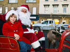 Five-year-old Freedom Pfeifer jumped aboard Santa's sleigh last Friday, Nov. 20 to pose for a picture with the jolly ol’ man and one of his reindeer during the Mitchell BIA's downtown party. GALEN SIMMONS/MITCHELL ADVOCATE