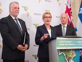 Ontario Premier Kathleen Wynne, centre, speaks to reporters accompanied by Quebec Premier Philippe Couillard and California Governor Jerry Brown at the Climate Summit of the Americas in Toronto on Wednesday, July 8, 2015. (THE CANADIAN PRESS/Darren Calabrese)