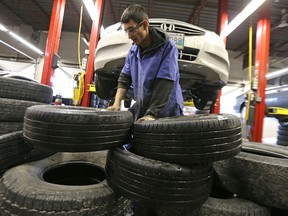 Staff switch a vehicle over to winter tires at the KAL Tire location on Pembina Highway in Winnipeg on Sat., Nov. 21, 2015. Kevin King/Winnipeg Sun/Postmedia Network