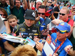 NASCAR Sprint Cup Series driver Jeff Gordon is surrounded by fans and media as he signs autographs during practice for the Ford Ecoboost 400 at Homestead-Miami Speedway. Mark J. Rebilas-USA TODAY Sports