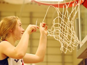 Lo-Ellen Knights' Taylin Legault cuts down the net from the basketball rim after the Knights won the NOSSA A championship on Saturday.