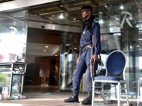 A Malian police officer stand guard outside the Radisson Blu hotel in Bamako on November 21, 2015, a day after a deadly attack. Investigators in Mali are hunting at least three people suspected of links to the jihadist siege at the luxury Radisson Blu hotel in the capital that left at least 19 people dead. AFP PHOTO / ISSOUF SANOGO
