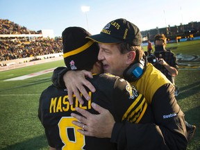 Hamilton Tiger-Cats' head coach Kent Austin whispers in the ear of Hamilton Tiger-Cats' quarterback Jeremiah Masoli. (THE CANADIAN PRESS/Peter Power)