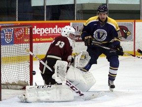 Laurentian Voyageurs' Brad MacDonald, right, looks for a scoring opportunity as a shot flies wide past Concordia Stingers goaltender Miguel Sullivan during OUA men's hockey action at Gerry McCrory Countryside Sports Complex in Sudbury on Saturday night. Ben Leeson/The Sudbury Star/Postmedia Network