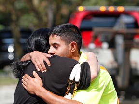 Zaher Al-Ramadhan, a tow truck driver with Jonny's Towing, hugs the wife of Abbas Kadir, the tow truck operator who was critically injured while responding to a call last week on Highway 417. The two embraced after a rally for Kadir ended at Ottawa's Civic Hospital on Sunday, Aug. 31, 2015.
MATT DAY/OTTAWA SUN