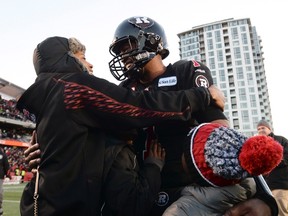 Ottawa Redblacks' quarterback Henry Burris celebrates his win with his family after defeating the Hamilton Tiger-Cats in the CFL East Division final in Ottawa Sunday, Nov. 22, 2015. THE CANADIAN PRESS/Sean Kilpatrick
