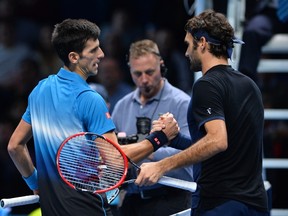 Switzerland's Roger Federer (R) greets Serbia's Novak Djokovic after losing the men's singles final match against Switzerland's Roger Federer on day eight of the ATP World Tour Finals tennis tournament in London on November 22, 2015. 
AFP PHOTO / GLYN KIRK