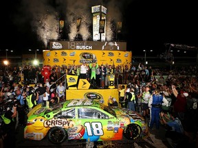 Kyle Busch, driver of the #18 M&M's Crispy Toyota, celebrates with the trophy in Victory Lane after winning the series championship and the NASCAR Sprint Cup Series Ford EcoBoost 400 at Homestead-Miami Speedway on November 22, 2015 in Homestead, Florida.   Sean Gardner/Getty Images/AFP