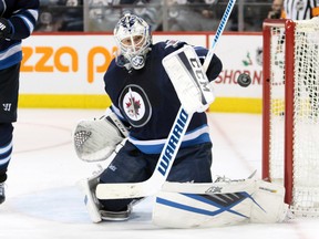 Nov 21, 2015; Winnipeg, Manitoba, CAN;  Winnipeg Jets  goalie  Michael Hutchinson (34) makes a save during the third period against the Arizona Coyotes at MTS Centre. Winnipeg wins 3-2. Mandatory Credit: Bruce Fedyck-USA TODAY Sports