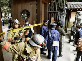Police officers and fire fighters investigate at the south gate of Japan's controversial Yasukuni Shrine where there was an explosion and burned the ceiling and wall of the public bathroom, in Tokyo, Japan, in this photo taken by Kyodo November 23, 2015. An apparent explosion at Japan's controversial Yasukuni Shrine for the war dead in Tokyo on Monday damaged the ceiling and the wall of a public bathroom south of the shrine, Kyodo news agency reported. (REUTERS/Kyodo)