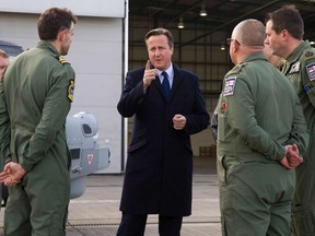 Britain's Prime Minister David Cameron (C) chats with Royal Navy personnel at RAF Northolt in London, Britain November 23, 2015. Britain will invest an extra 12 billion pounds (US$18 billion) in defence equipment over the next 10 years Cameron said on Monday.  REUTERS/Justin Tallis/pool