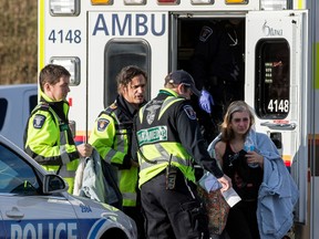 A woman is tended to by paramedics along the transit way near highway 174 in Ottawa on Monday November 23, 2015. 
Errol McGihon/Ottawa Sun/Postmedia Network