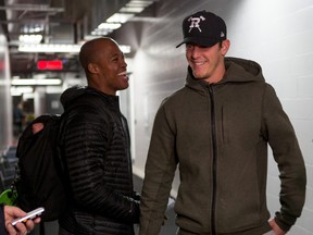 Ottawa RedBlacks quarterback Henry Burris (L) smiles as he crosses paths with receiver Greg Ellingson before speaking with members of the media the day after their team defeated the Hamilton Tiger Cats to to win the Eastern championship and earn a spot in Grey Cup taking place in Winnipeg next Sunday. Monday November 23, 2015. Errol McGihon/Ottawa Sun/Postmedia Network