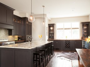 In this kitchen, recessed pot lights provide ambient lighting, island pendants provide task lighting and decorative lighting can be found in the glass cabinetry.