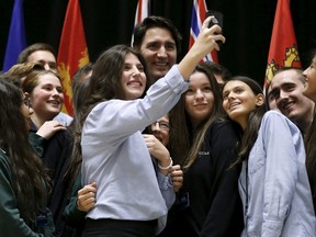 Prime Minister Justin Trudeau (C) poses for a selfie with students during the First Ministers' meeting in Ottawa, Canada November 23, 2015. REUTERS/Chris Wattie
