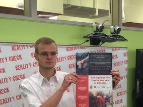 Hennes Doltze, Salvation Army correctional and justice services rep, holds up poster for Reality Check initiative at press conference held at Petersen Hall on Monday, Nov. 23, 2015.