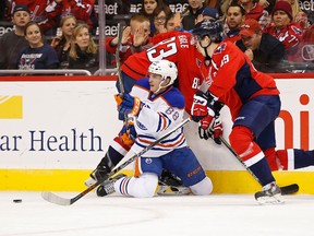 Oilers defenceman randon Davidson goes down against the boards while battling Capitals center Jay Beagle (83) and right wing Stanislav Galiev for the puck during Monday's game in Washington. (USA TODAY SPORTS)