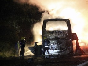 A firefighter tries to extinguish a bus on fire after it crashed in a highway of Puebla State, in the Jalpan municipality, on November 22, 2015. (AFP PHOTO/STR)