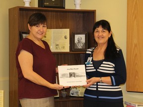 Sylvie Lavoie-Girard and Suzanne Gadoury hold a copy of the book published to commemorate the 100th anniversary of the Lady Minto Hospital. It contains photos and stories from the century of service to the local community.