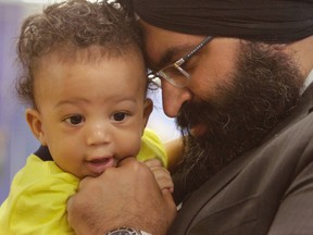 Manmeet Bhullar holds Navani Davis, 6 months, following a press conference in Calgary, Alta on Thursday May 22, 2014. (Jim Wells/Calgary Sun file)