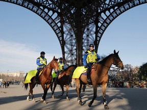 Mounted police officers patrol under the Eiffel Tower in Paris, Monday Nov. 23, 2015. (AP Photo/Laurent Cipriani)