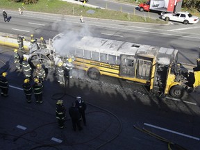 Investigators and firefighters work the scene of a fire and shooting Tuesday, Nov. 24, 2015, in Philadelphia. A Pennsylvania state police trooper was shot in the shoulder after a fiery crash on a Philadelphia highway. Officials said three suspects are in custody and the trooper has been hospitalized in stable condition. (AP Photo/Matt Rourke)