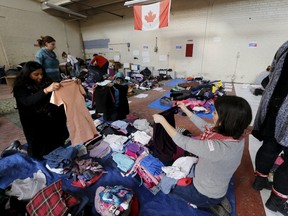 Clothing donated for an expected influx of Syrian refugees is sorted by volunteers for size and gender at a theatre rehearsal space in Toronto. (REUTERS/Chris Helgren)