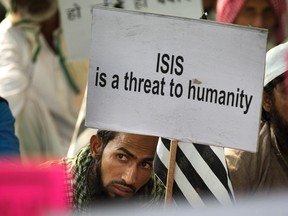 An Indian Muslim man holds a banner during a protest against ISIS, an Islamic State group, and Friday's Paris attacks, in New Delhi, India, Wednesday, Nov. 18, 2015. Multiple attacks across Paris on Friday night have left more than one hundred dead and many more injured. (AP Photo/Manish Swarup)