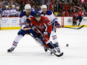 Oilers defenceman Darnell Nurse strips Capitals forward Evgeny Kuznetsov of the puck during Monday's game in Washington. (AP Photo)