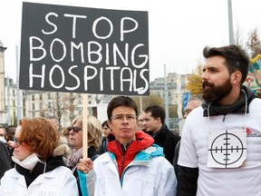 The staff of Medecins Sans Frontieres, MSF, (Doctors Without Borders)  hold posters, during a demonstration  in Geneva, Switzerland, Tuesday, Nov. 3, 2015. They  gathered  to protest  against the US  air strike on  their charity-run hospital in Kunduz in Afghanistan one month ago. (Salvatore Di Nolfi/Keystone via AP)