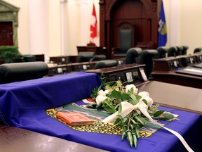 An Alberta flag and white roses are draped over the desk of Calgary MLA Manmeet Bhullar inside the Alberta Legislature chambers in Edmonton Alta, on Tuesday Nov. 24, 2015. Bhullar, 35, was killed in a vehicle accident after he stopped to help other motorists on Monday Nov. 23, 2015 while driving from Calgary to Edmonton during a snow storm. Photo Courtesy/Alberta Government