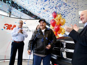 Gino Donato/Sudbury Star
Ron Proulx, a welder at Bristol Machine, was the winner in 3M Canada's 3M Cubitron 2 Discs "Grind Like a Legend 2" contest and was awarded his brand new Ram 1500 SLT pickup in Sudbury on Tuesday. Blake Didone, right, co-owner of Doyle Dodge Chrysler Jeep Ram, looks on as Proulx is awarded his prize. The contest was held from April 1 to July 31 across Canada. A sticker with a unique code was placed on the Cubitron 2 product and users entered the code online. Three finalist were drawn and taken to a Motley Crue concert in Montreal where the grand prize winner was announced.