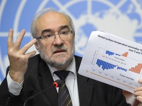 Secretary-General of the World Meteorological Organization (WMO) Michel Jarraud shows a document on global surface temperature anomalies between 1880 and 2015 during a press conference on a five-year report on the climate from 2011-2015 on November 25, 2015 in Geneva. The year 2015 is shaping up to be the hottest on record, with the highest ocean surface temperatures ever measured, the UN's weather agency said ahead of a crucial climate change summit in Paris. (AFP PHOTO/FABRICE COFFRINI)