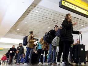 Travellers wait in line at a security checkpoint at La Guardia Airport in New York November 25, 2015. Millions of Americans embarked on their Thanksgiving travels on Wednesday with security in airports, at New York City's parade festivities, and other venues expected to be heightened amid jitters after the Paris attacks last week. REUTERS/Brendan McDermid