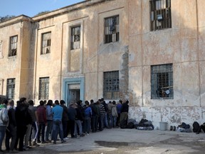 Refugees and migrants line-up during free food distribution at a temporary camp on the Greek island of Leros on Nov. 15, 2015. (REUTERS/Fotis Plegas)