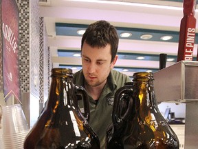 Staff were kept hopping filling orders at one of new growler bars at the Liquor Mart on Kenaston Boulevard on Fri., Oct. 24, 2014.