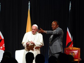 Kenyan President Uhuru Kenyatta (R) gestures next to Pope Francis at the State House of Nairobi on November 25, 2015. Pope Francis said the world was facing a "grave environmental crisis" as he arrived in Kenya on Wednesday on a landmark Africa trip just days before a crucial UN summit aimed at curbing climate change. AFP PHOTO / JOHN MUCHUCHA