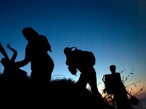 Syrian refugees leave from the coast after they arrive aboard a dinghy from Turkey, to the island of Lesbos, Greece, in this Sept. 20, 2015 file photo. (AP Photo/Petros Giannakouris)