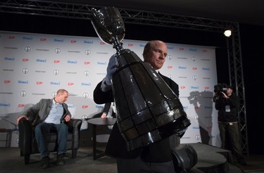 Jeff McWhinney carries the Grey Cup prior to the start of a news conference with Ottawa Redblacks head coach Rick Campbell and Edmonton Eskimos head coach Chris Jones in Winnipeg on Wednesday, Nov. 25, 2015. The Redblacks will play the Edmonton Eskimos in the 103rd Grey Cup on Sunday. THE CANADIAN PRESS/Jonathan Hayward