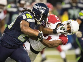 Seattle Seahawks running back Marshawn Lynch (24) stiff arms Arizona Cardinals cornerback Patrick Peterson (21) during NFL play Nov. 15 at CenturyLink Field. (Troy Wayrynen/USA TODAY Sports)