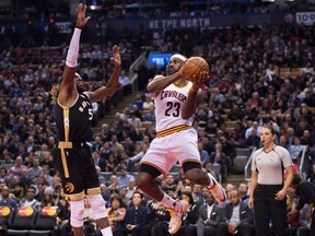 Cleveland Cavaliers' Lebron James looks to pass over Toronto Raptors' DeMarre Carroll during second half NBA basketball action in Toronto on Wednesday, November 25, 2015. (THE CANADIAN PRESS/Darren Calabrese)