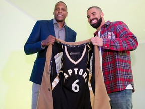 Toronto Raptors GM Masai Ujiri, left, and rapper Drake pose with a coat lined with a Raptors jersey at Drake Night prior to NBA basketball action between the Raptors and Cleveland Cavaliers in Toronto on Wednesday, November 25, 2015. (THE CANADIAN PRESS/Darren Calabrese)