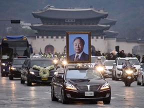 A motorcade carrying the casket of former president Kim Young-Sam makes its way past Gyeongbokgung palace and Gwanghwamun square in central Seoul on November 26, 2015. In freezing temperatures and light snowfall, South Korea held a state funeral for former president Kim Young-Sam, whose 1992 election victory brough a formal end to more than 30 years of military rule. AFP PHOTO / Ed Jones