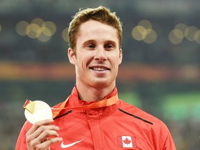 Canada's gold medallist Derek Drouin poses on the podium during the victory ceremony for the men's high jump athletics event at the 2015 IAAF World Championships at the "Bird's Nest" National Stadium in Beijing on Aug. 30. The Corunna native has been nominated for Air Canada's athlete of the year honours. The winner is to be announced Dec. 11. (AFP PHOTO / GREG BAKER)