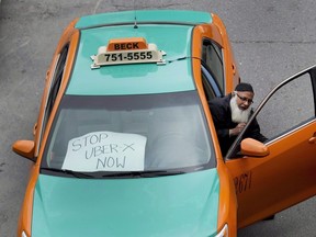 A taxi driver protests Uber in Toronto on June 1, 2015. The Competition Bureau says local regulations on the taxi industry need to be overhauled to deal with new competition from alternatives like the ride-hailing service Uber. New competitors have gained market share by undercutting the fixed prices of existing cabs and skirting regulations for the industry. THE CANADIAN PRESS/Nathan Denette