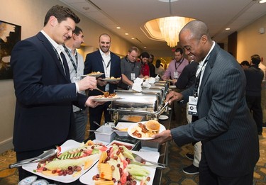 Ottawa Redblacks quarterback Henry Burris, right, fixes his breakfast with teammates during the team breakfast before the up coming CFL 103rd CFL Grey Cup game against the Edmonton Eskimos in Winnipeg, Man., on Thursday, November 26, 2015. THE CANADIAN PRESS/Nathan Denette