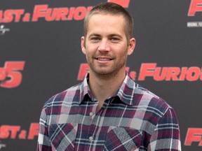 In this April 29, 2011, file photo, actor Paul Walker poses during the photo call of the movie "Fast and Furious 5," in Rome. Walker's father sued Porsche on Wednesday, Nov. 25, 2015, for wrongful death,  claiming the Porsche sports car he was riding in was defective and lacked safety features that might have saved his life during a 2013 crash in Valencia, Calif.  (AP Photo/Andrew Medichini, File)
