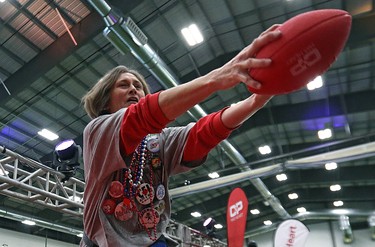 Kelly McKeating reaches out to grab a football as she dives into a foam pit during the MacDon Fan Experience and Family Zone at the Axworthy Health & Recplex on the University of Winnipeg campus on Thu., Nov. 26, 2015. Kevin King/Winnipeg Sun/Postmedia Network