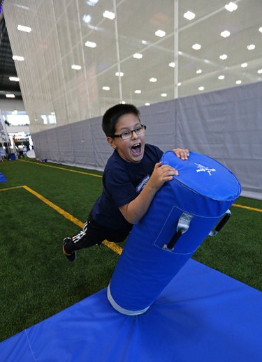 A young boy launches himself at a tackling dummy during the MacDon Fan Experience and Family Zone at the Axworthy Health & Recplex on the University of Winnipeg campus on Thu., Nov. 26, 2015. Kevin King/Winnipeg Sun/Postmedia Network