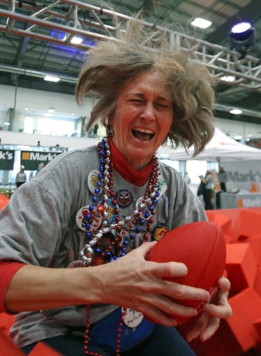 Kelly McKeating laughs after catching a football as she dove into a foam pit during the MacDon Fan Experience and Family Zone at the Axworthy Health & Recplex on the University of Winnipeg campus on Thu., Nov. 26, 2015. Kevin King/Winnipeg Sun/Postmedia Network